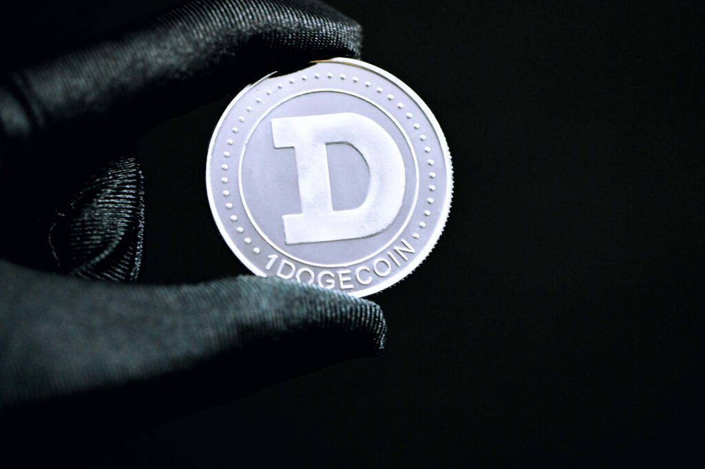 Shiny Dogecoin with bold D emblem glowing against cosmic stars and golden galactic background Wallpaper
