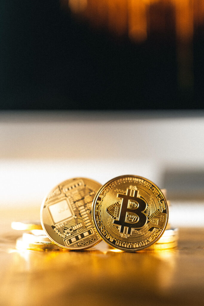 Close-up of shiny gold Bitcoin and cryptocurrency coins with intricate digital designs background Wallpaper