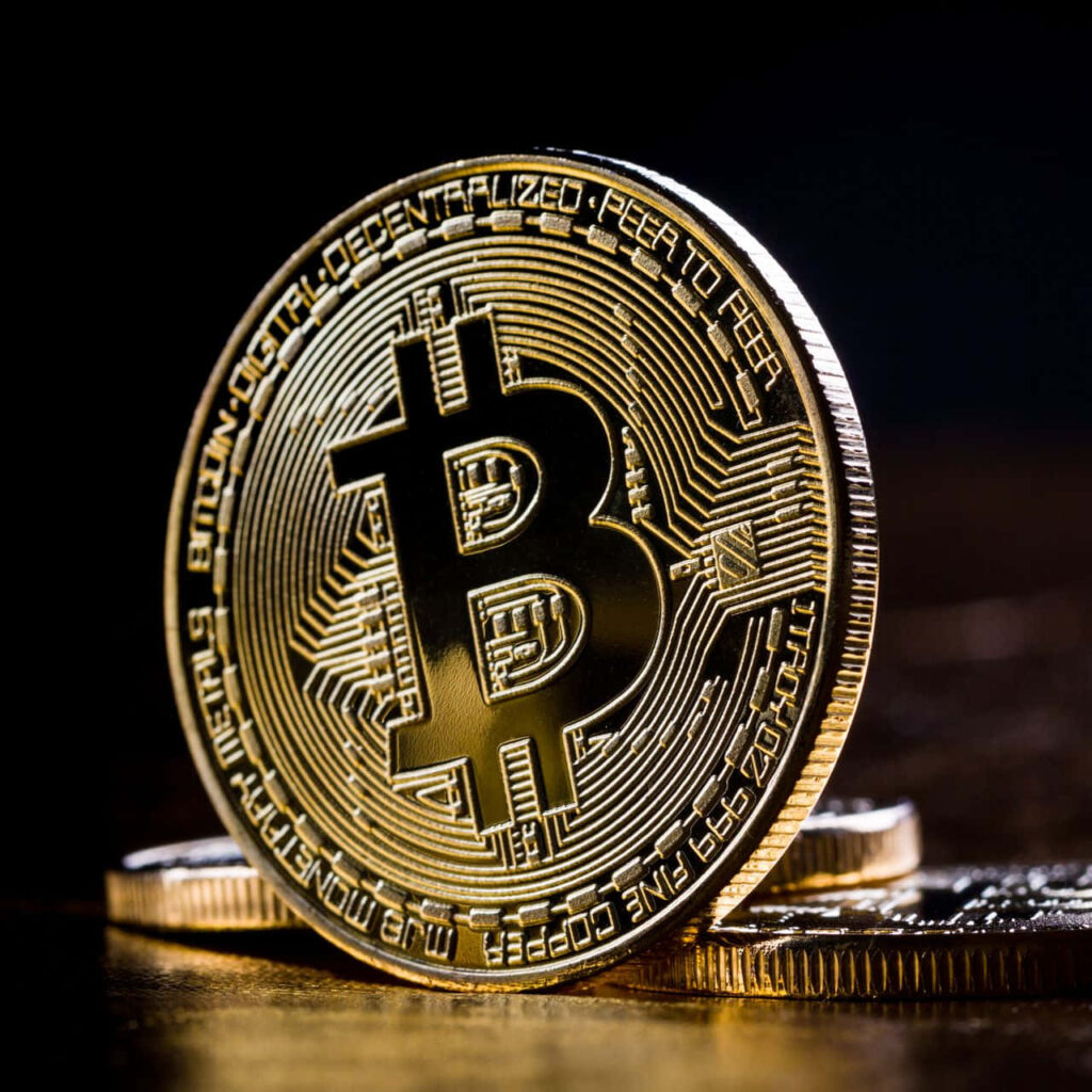 Close-up of shiny golden Bitcoin coin representing cryptocurrency revolution and digital economy growth Wallpaper