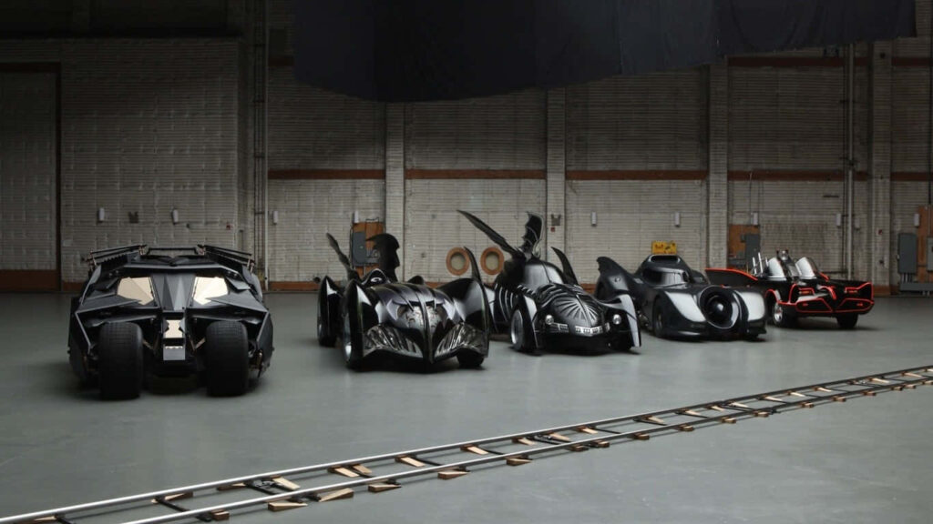 Various Models of the Batmobile Amidst a Gray Backdrop Wallpaper