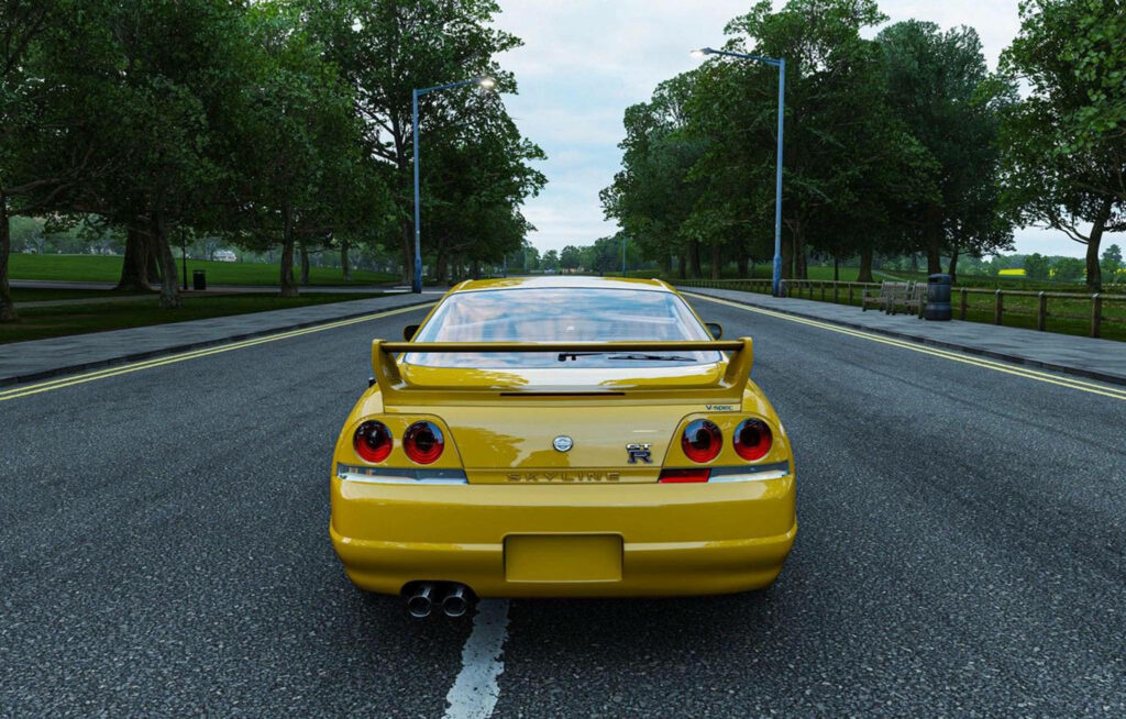 Roaring R33: Capturing the Majesty of a Yellow Nissan Skyline GTR Model on the Open Road Wallpaper