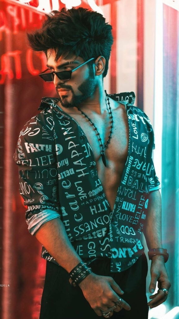 Confident young man in trendy shirt and sunglasses with red cyan neon urban background wallpaper