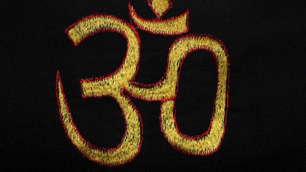 Om Embroidery Bliss: A Vibrant Wallpaper of Sacred Symbol
