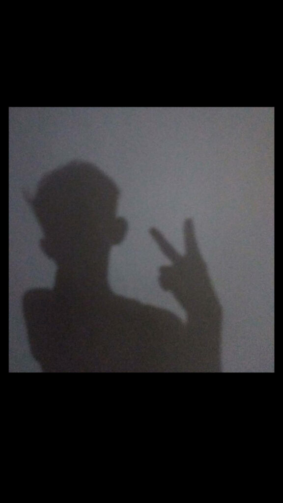 Peaceful Boy Silhouette Casting Calm Shadow on Plain Background Wallpaper