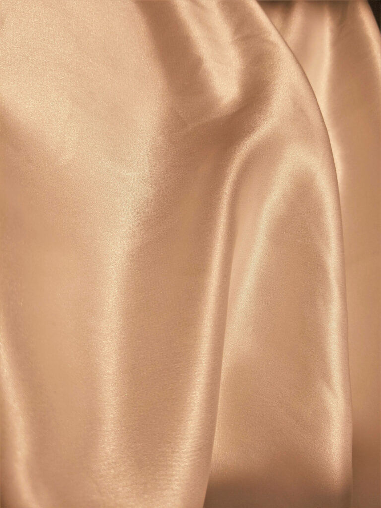 Silken Tides: A Captivating Close-up of an Orange Ripple-Textured Fabric Wallpaper