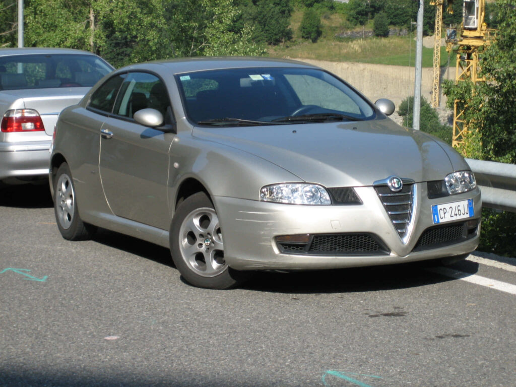 Silver Alfa Romeo GT parked roadside with sleek Italian design and green background cars Wallpaper