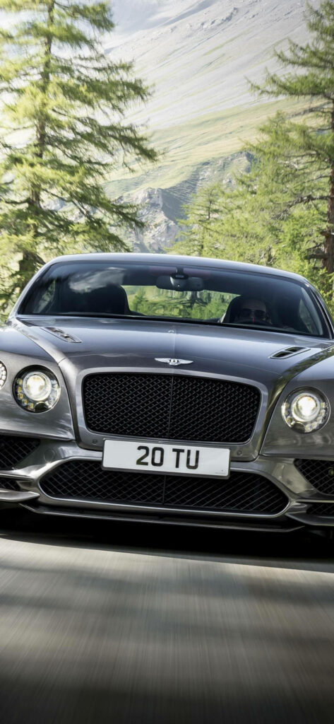 Silent Elegance: Silver Bentley Continental Cruising Majestically on a Scenic Mountain Highway - iPhone Wallpaper