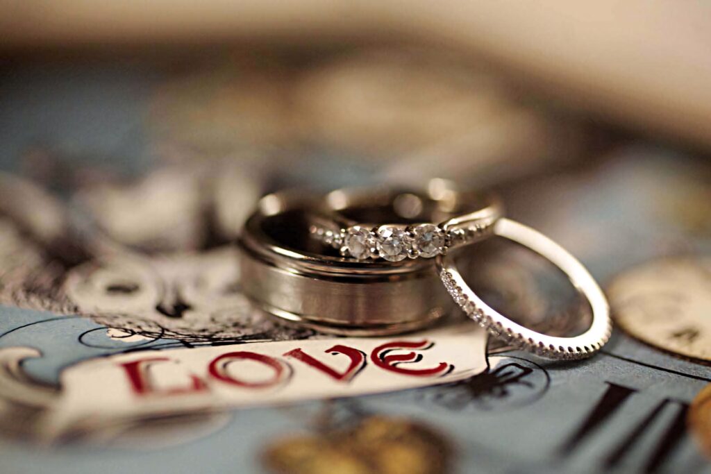 Silver engagement rings with diamonds on colorful love-themed artistic wallpaper background