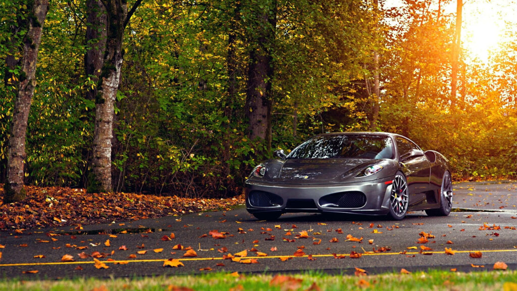 Autumn's Rush: Roaring Along the Lone Highway in a Silver Ferrari F430 Wallpaper