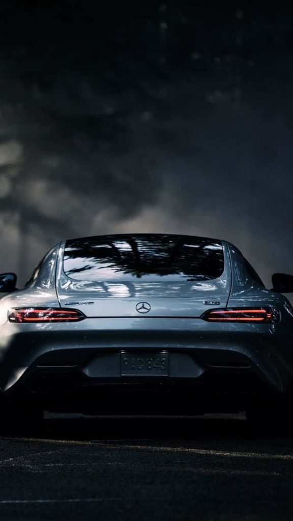 Silver Mercedes AMG GT rear view with LED taillights and tree reflections in moody setting Wallpaper