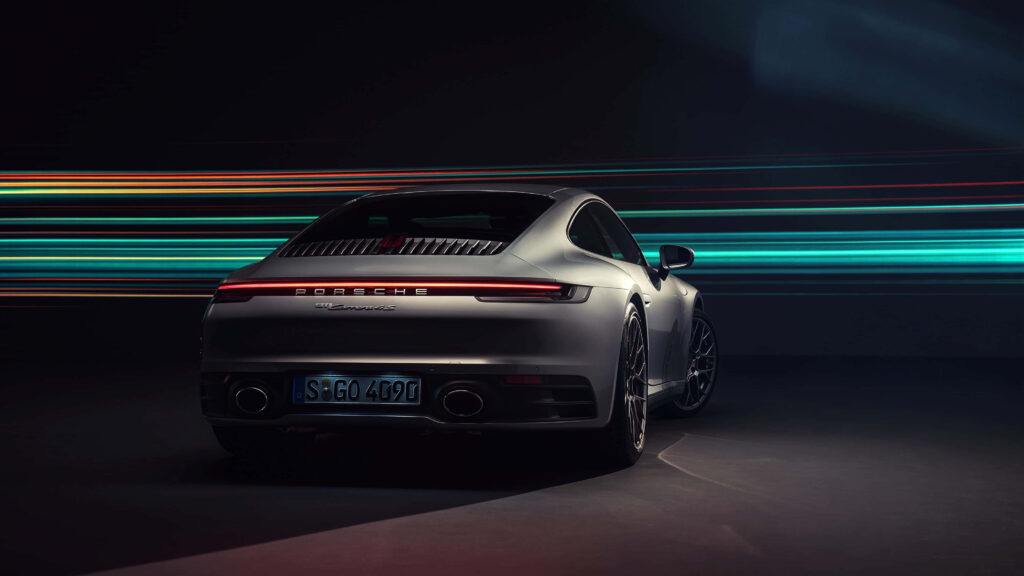 Silver Porsche sports car in 4K Ultra HD with vibrant light trails on dark background wallpaper