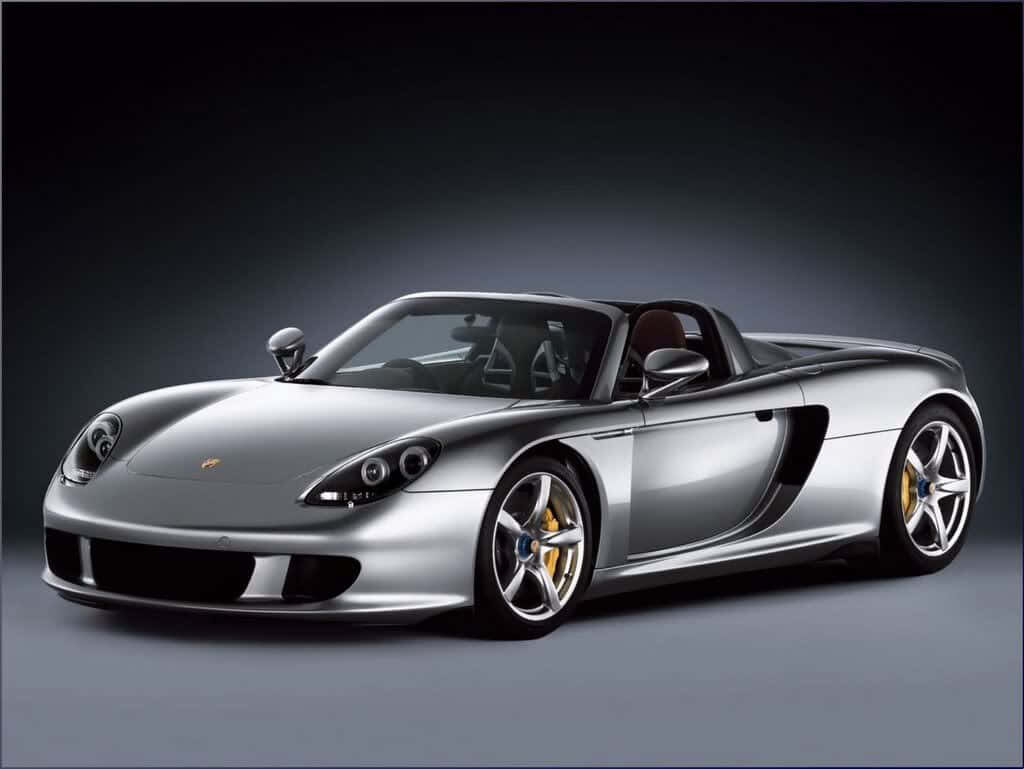 Silver Porsche Carrera GT in studio showcasing sleek design high-performance car wallpaper background