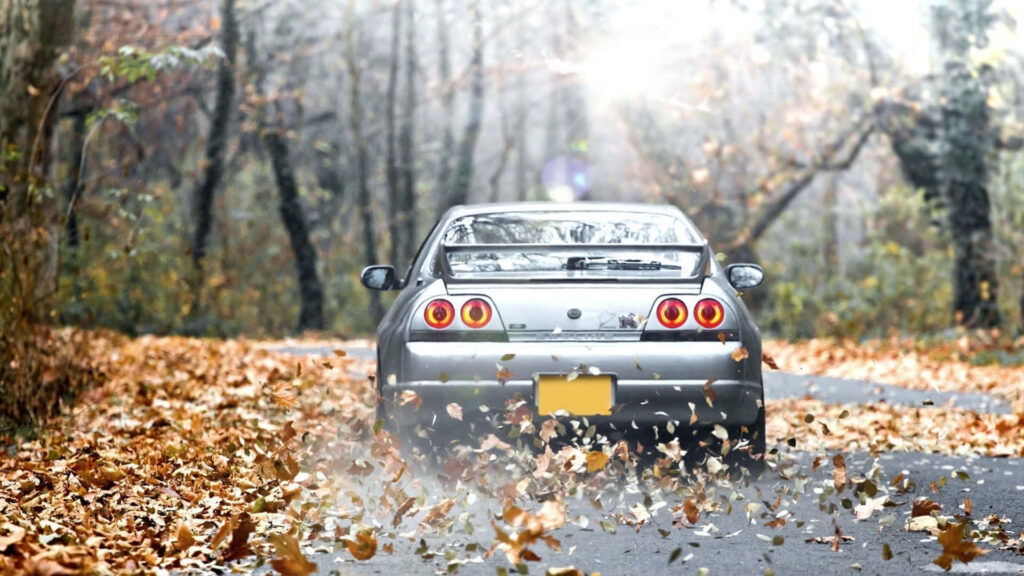 Silver R33 GTR driving on autumn forest road with colorful fall leaves wallpaper background