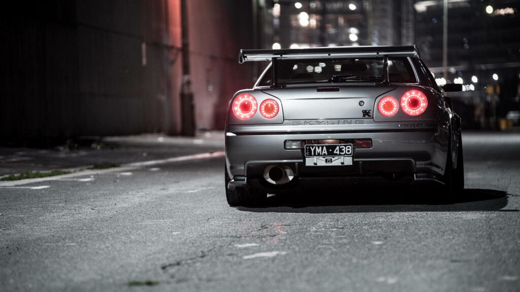 Nissan Skyline GT-R R34 Shines in Urban Nightscapes Wallpaper