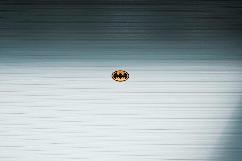 Silver Textured Backdrop Amplifies the Iconic Heroism of Batman's DC Logo Wallpaper