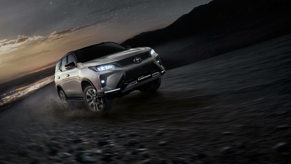 Silver Toyota Fortuner Legender speeding on rugged terrain at dusk showcasing bold design wallpaper