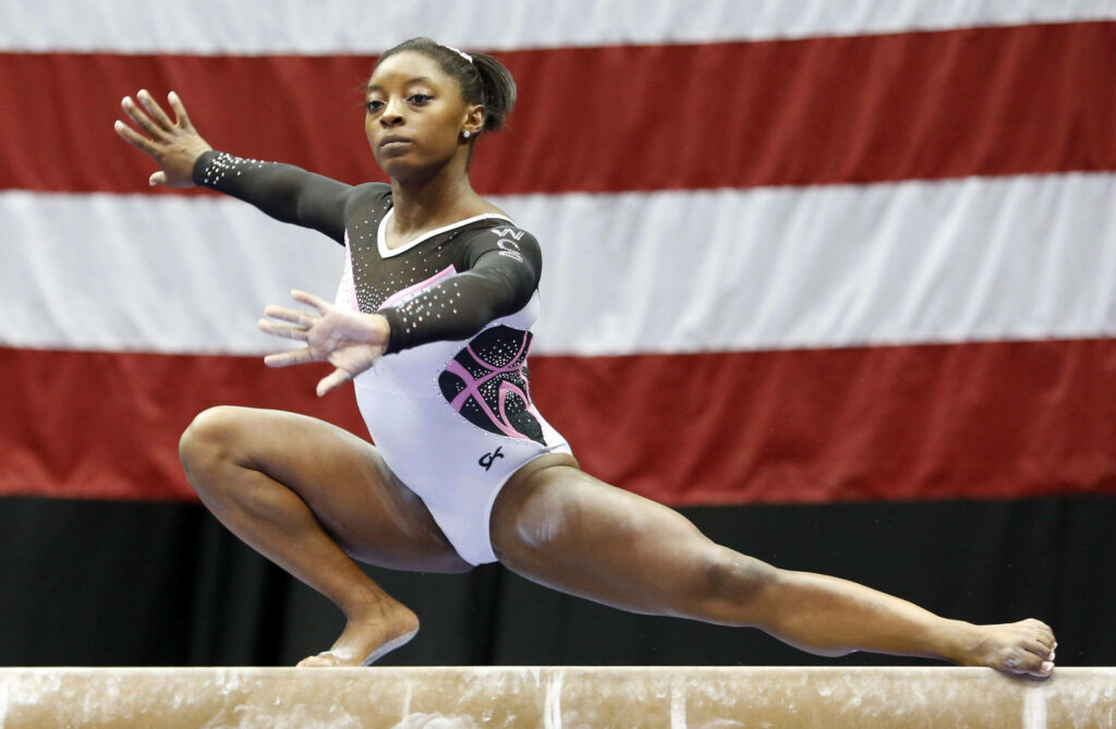 Simone Biles: Stunning Balance Beam Performance with American Flag Wallpaper