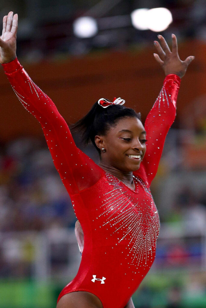 Simone Biles in Vibrant Red Leotard: Elegant Gymnastics Wallpaper
