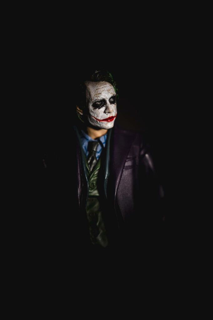 Silent Shadows: A Joker Phone Background with Enigmatic Character Gazing Sideways Wallpaper