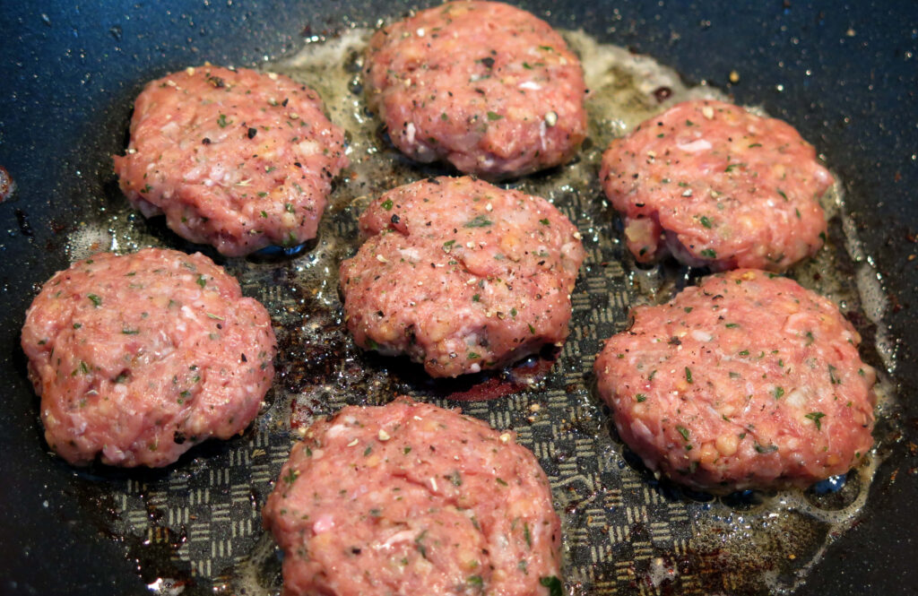 Delicious Hamburger Patties Cooking: Mouthwatering Wallpaper Background
