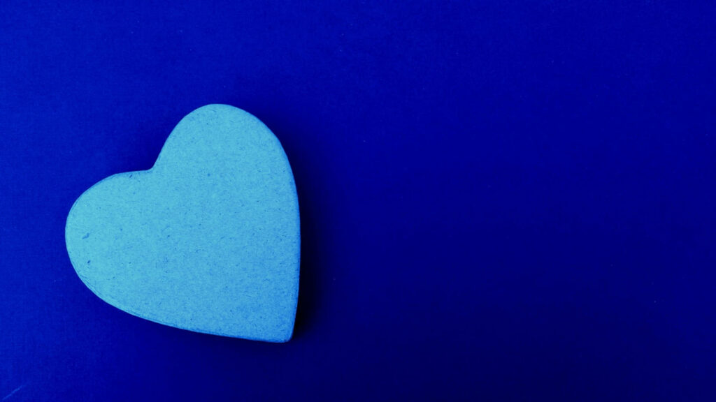 Serene Sky Blue Heart Shines on Royal Blue Canvas - Captivating Poster Design Wallpaper