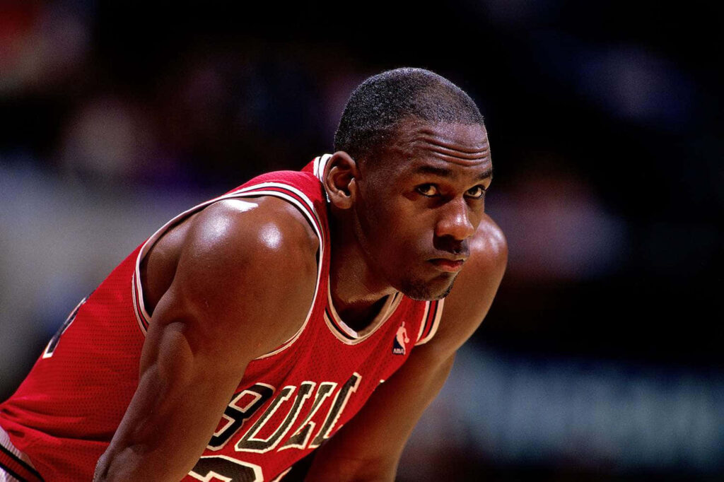 Airborne Mastery: Michael Jordan's Jaw-Dropping Basket Driving Dunk Wallpaper