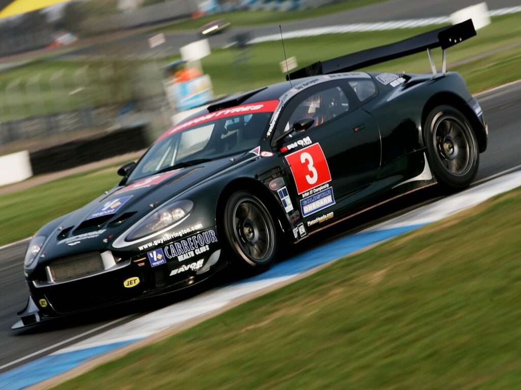 2005 Aston Martin DBRS9: Elegant Black Sports Car on Track Wallpaper