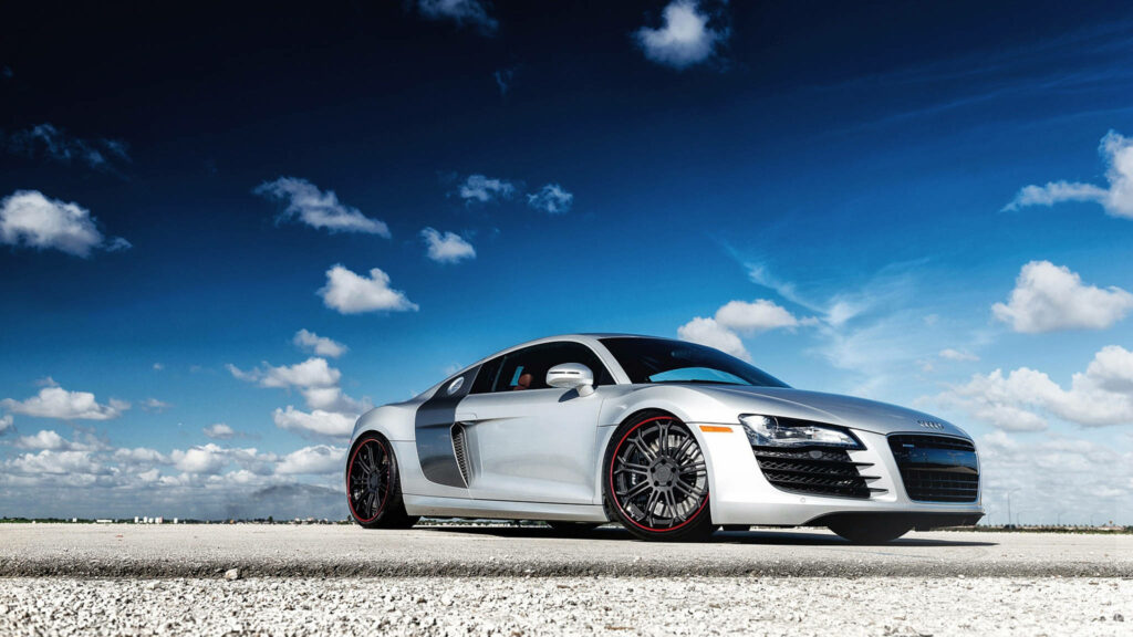 Sleek 2012 Audi R8 under vibrant blue sky showcasing stylish design and powerful presence wallpaper