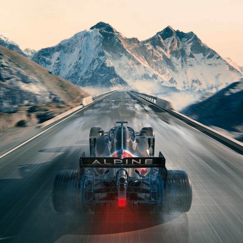 Alpine Formula 1 car racing on mountain road with snow-covered peaks and clear blue sky wallpaper