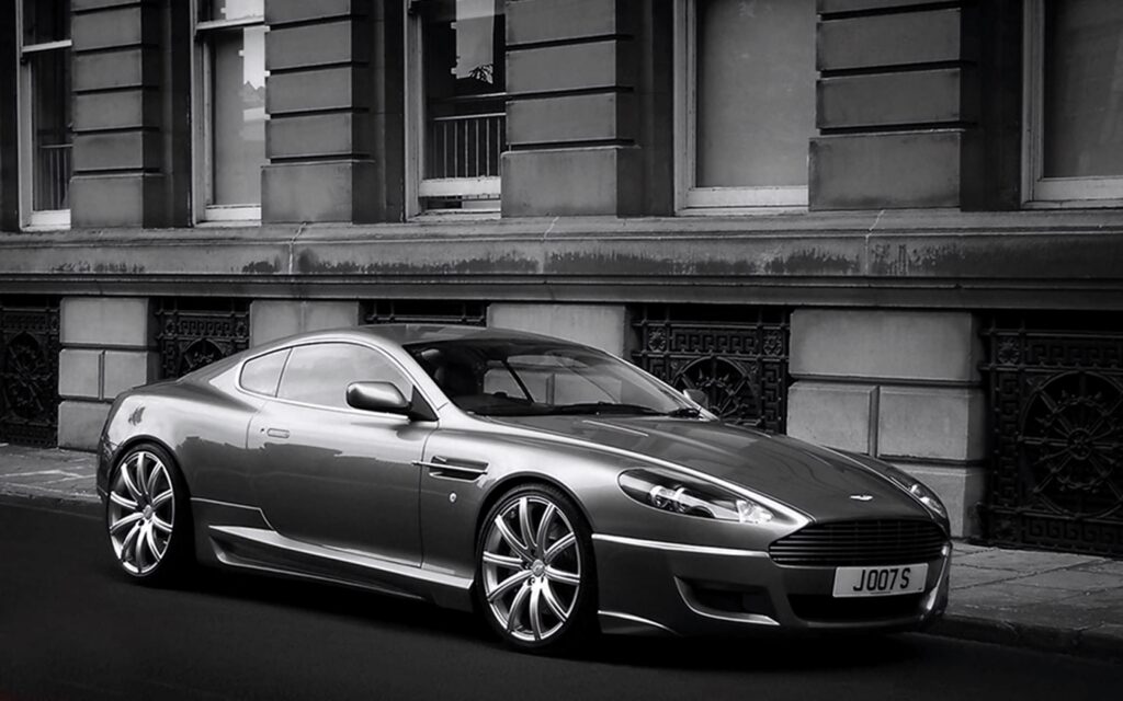 Aston Martin DB9 luxury car with polished metallic finish parked before classic building wallpaper