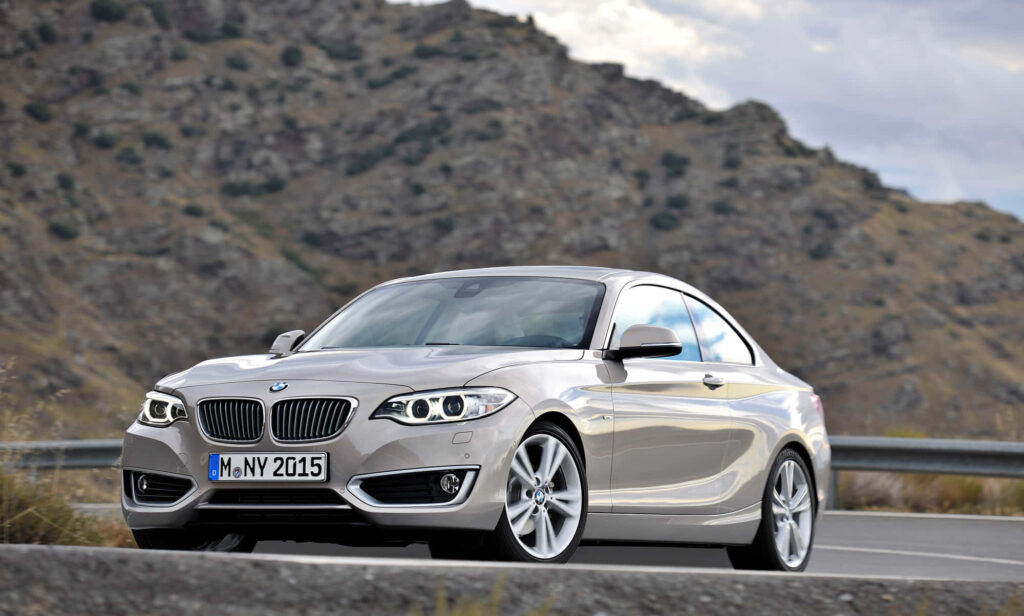 Stylish BMW 2 Series Wallpaper Against Majestic Mountain Backdrop