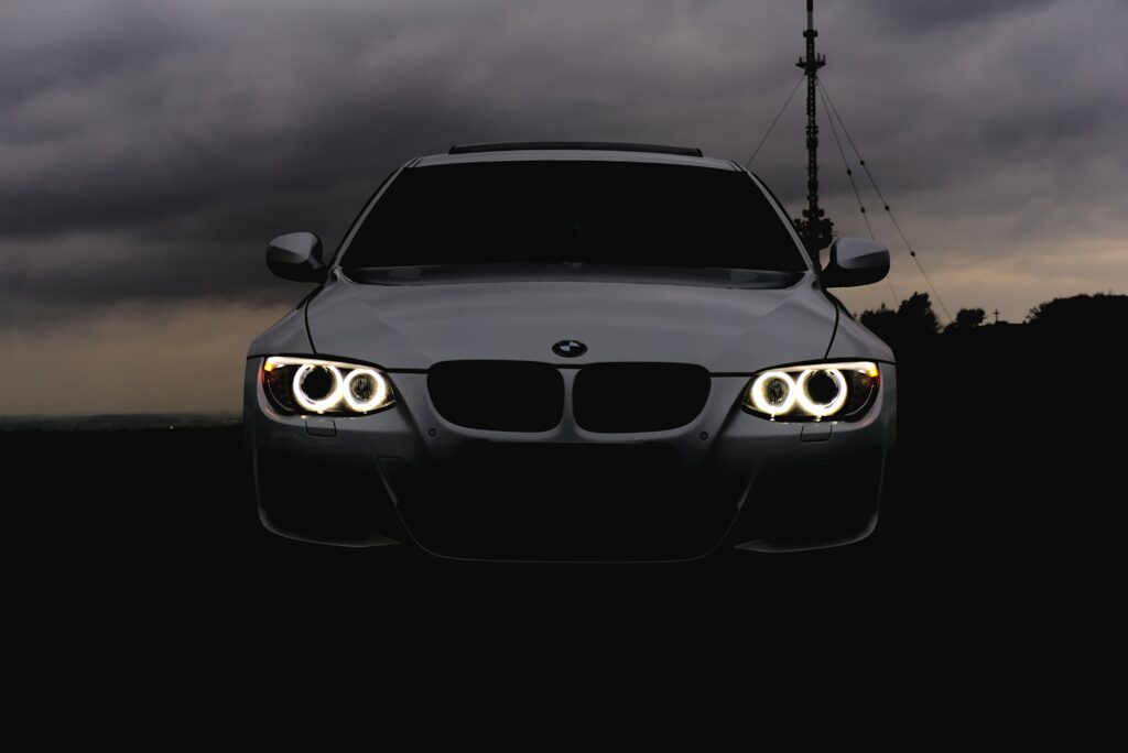 Sleek BMW Car with Distinctive Headlights Against Moody Sky Wallpaper