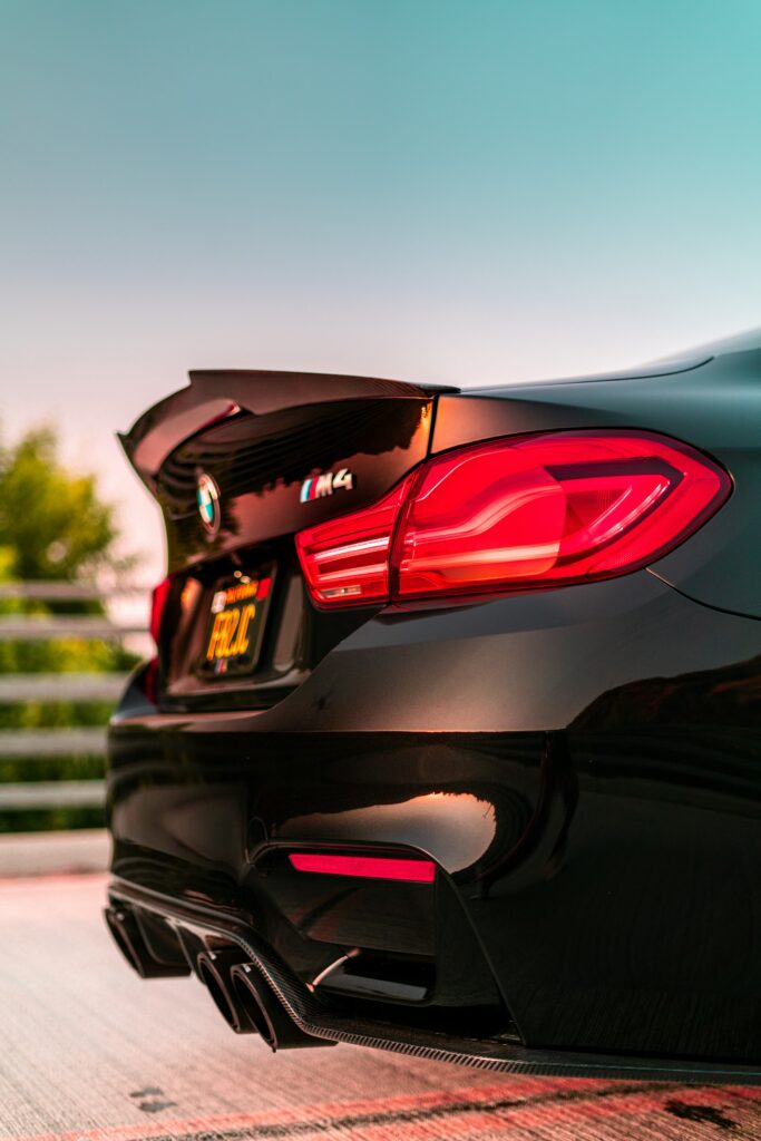 Close-Up of BMW M4 Taillight: Sleek Design Against Soft Blur Wallpaper