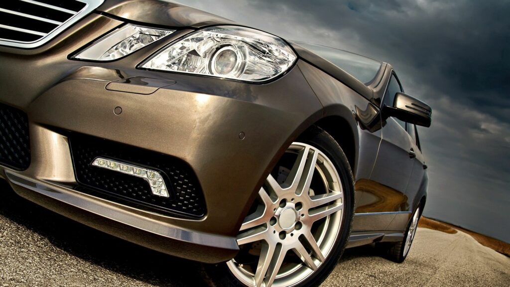 Stylish Beige Car in Cloudy Sky: Elegant Bumper & Headlights Focus Wallpaper