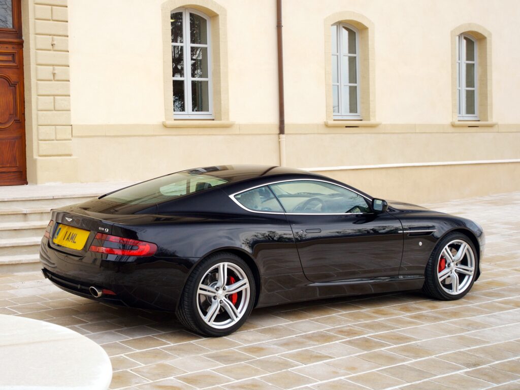 Elegant 2006 Aston Martin DB9 Wallpaper: Sleek Side View on Driveway