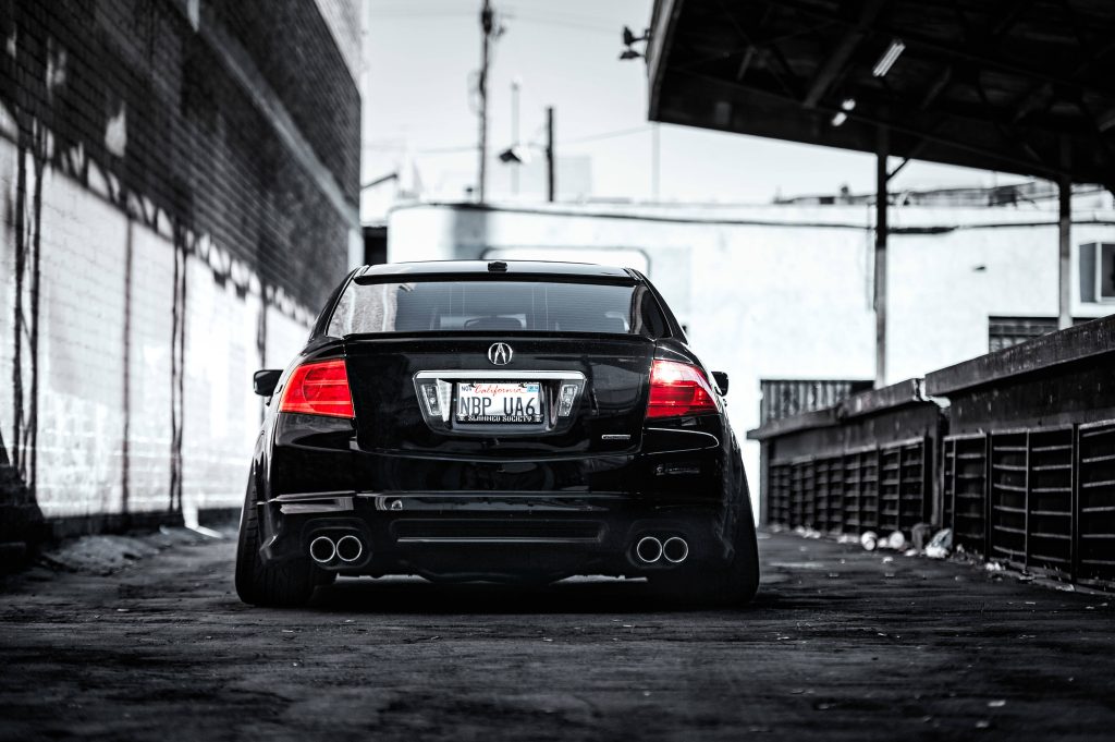Sleek black modified Acura TL UA6 rear profile lowered stance quad exhaust red taillights urban alley Wallpaper