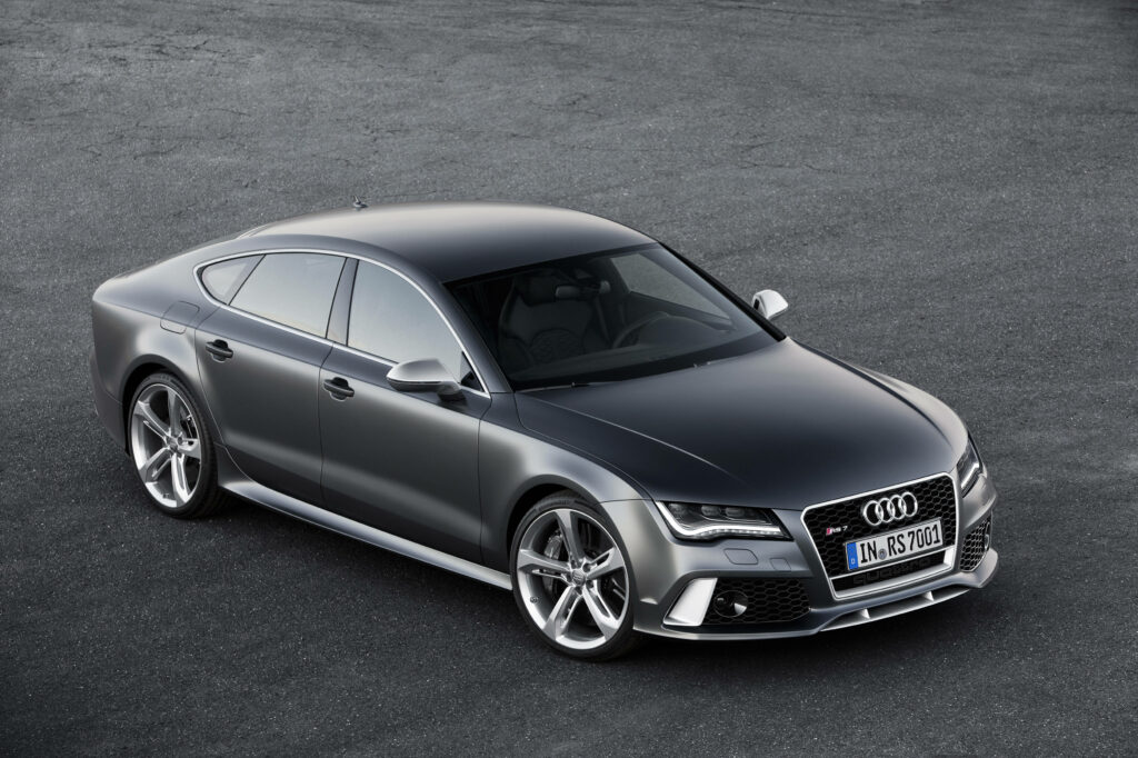 Sleek black Audi RS7 side view showcasing sporty design and dynamic lines on neutral background Wallpaper