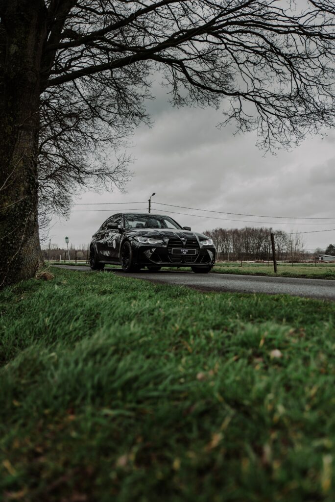 Stunning Black BMW M3 on Serene Road: Dramatic Nature Background Wallpaper