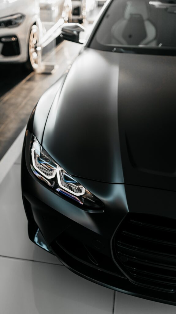 Sleek Black BMW M4: Striking Front View & Headlight Design Wallpaper