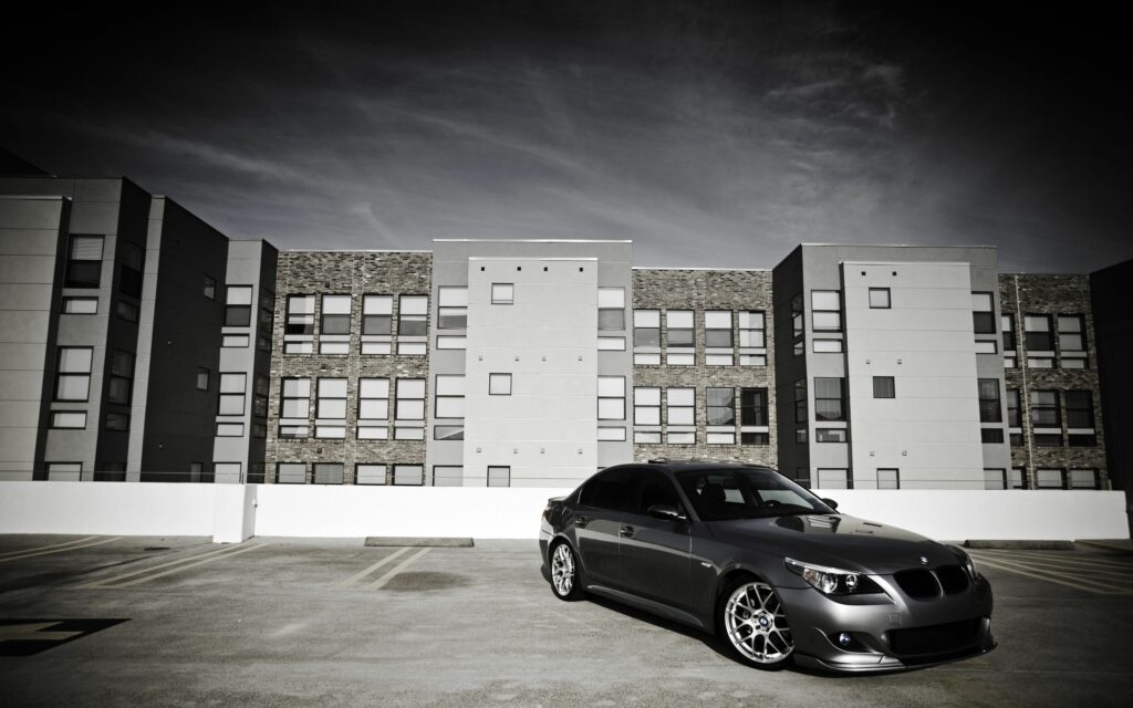 Sleek Black BMW on Rooftop: Modern Urban Background Wallpaper