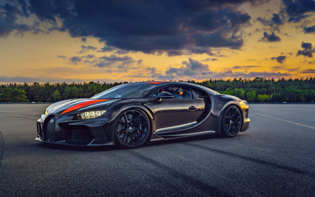 Black Bugatti Chiron on open road at sunset showcasing luxury power modern automotive design Wallpaper
