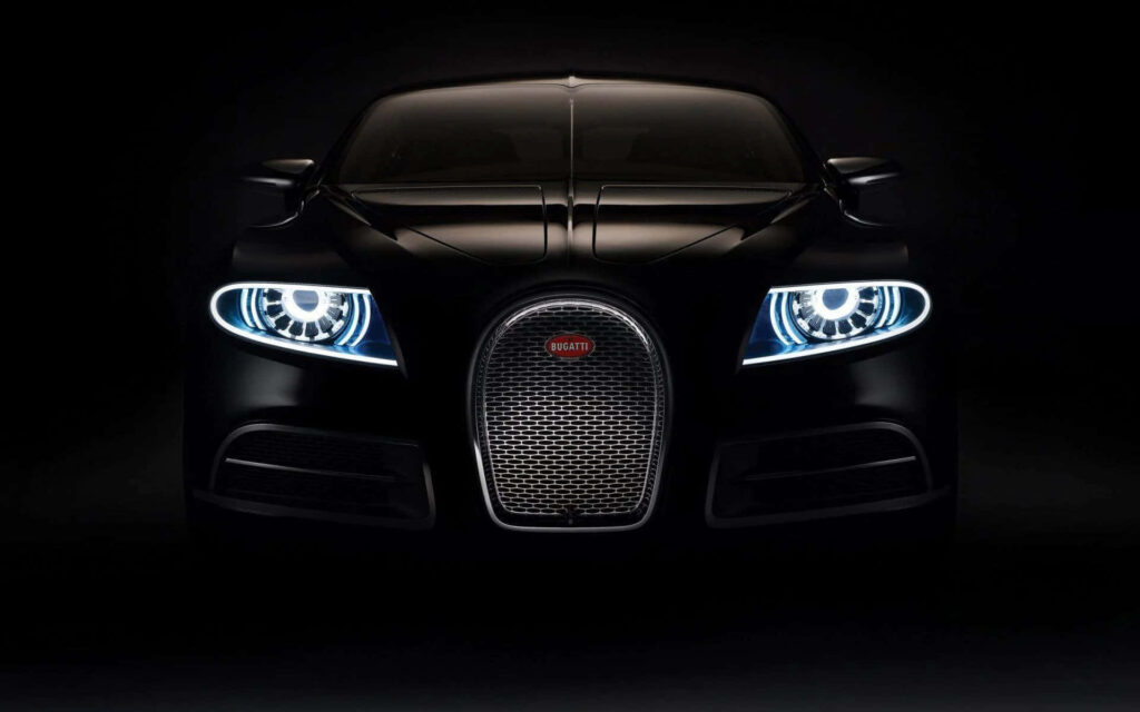 Sleek black Bugatti front view with glowing headlights and iconic grille on dark background wallpaper