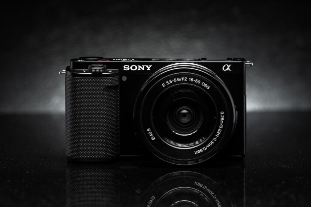 Sleek Black Camera with Detailed Lens on Glossy Monochrome Background Wallpaper