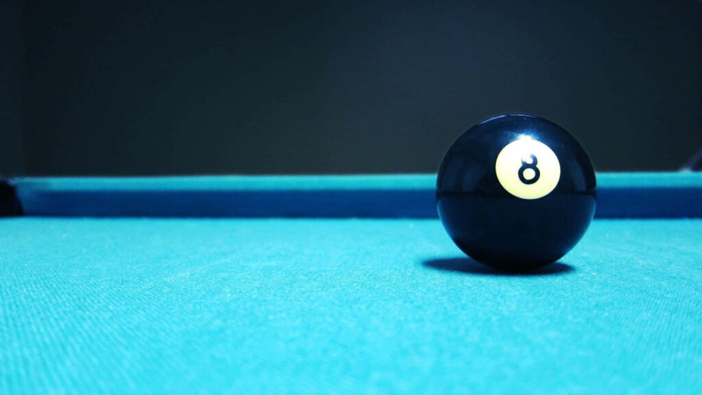 Sleek black eight-ball on vibrant teal pool table with dark minimalist background billiards wallpaper