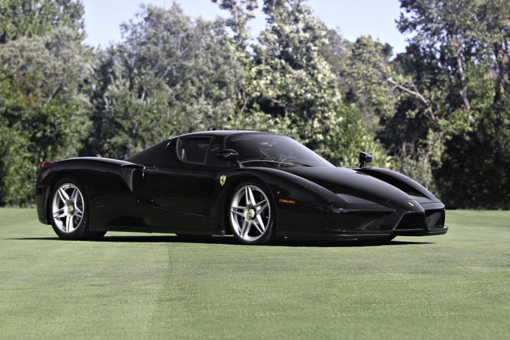 Stunning Black Ferrari Enzo Wallpaper on Lush Green Background