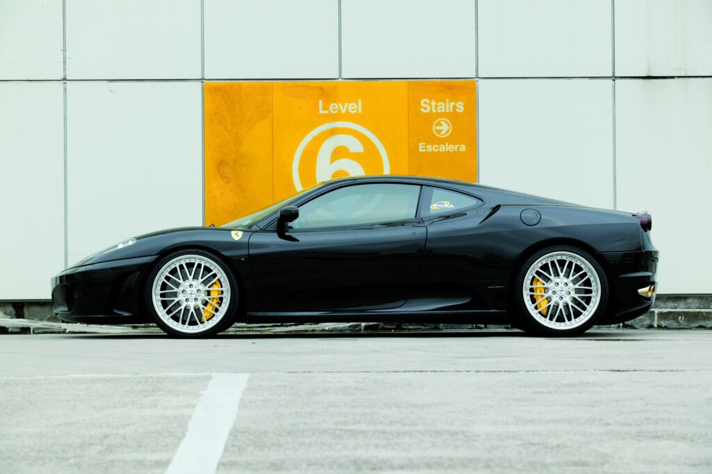 Sleek Black Ferrari F430 Side View Against Minimalist Level 6 Backdrop Wallpaper