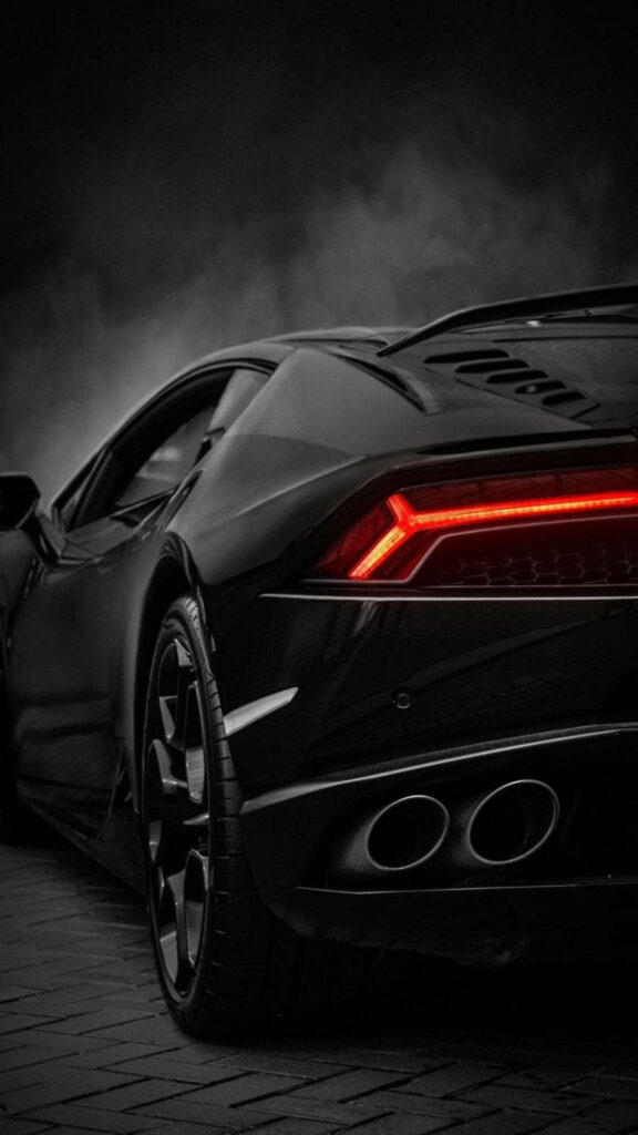 Rear view of sleek black Lamborghini Aventador with bold taillights on dark moody background Wallpaper
