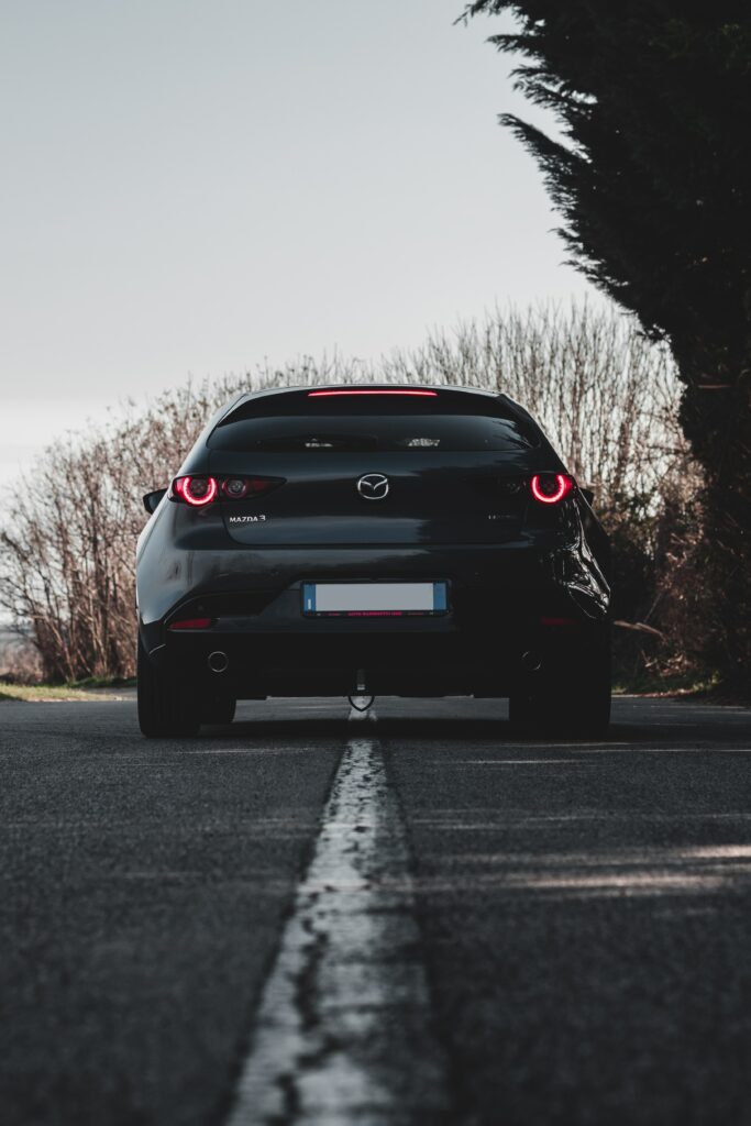 Stylish Black Mazda 3 on Road with Trees - Dynamic Wallpaper