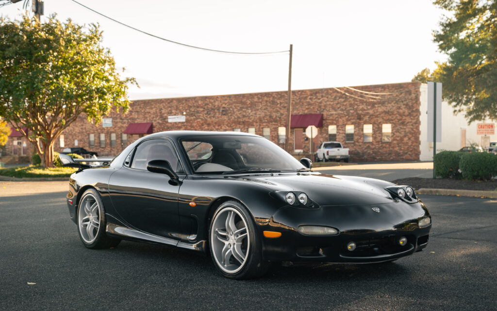 Sleek Black Mazda RX-7 Wallpaper: Sporty Design & Urban Backdrop