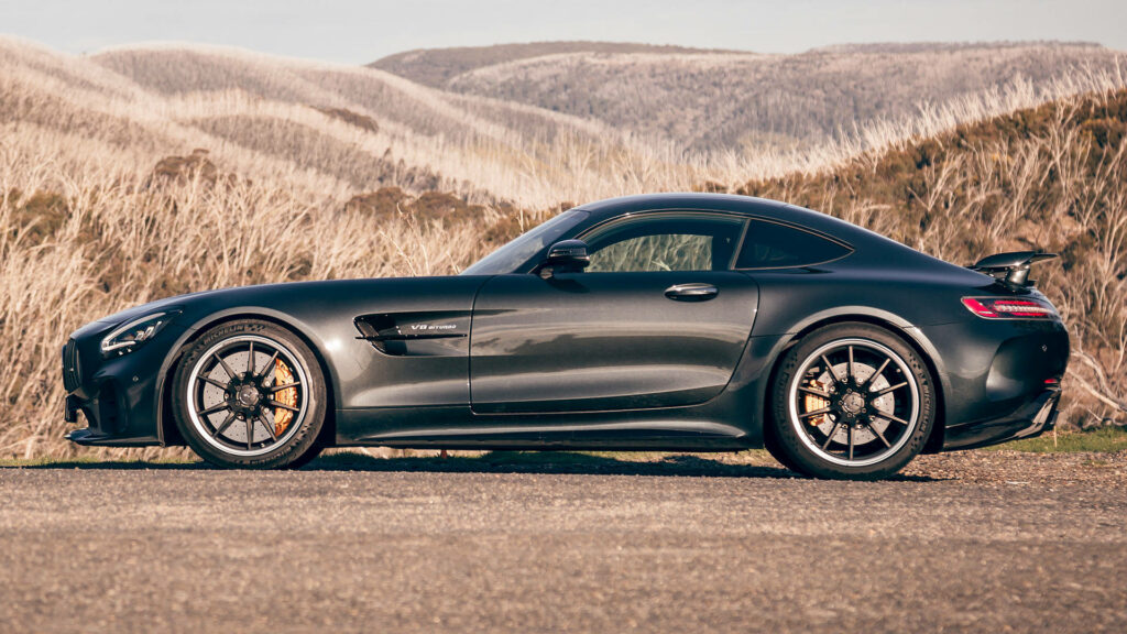 Black Mercedes AMG GT R side view with aerodynamic design on scenic outdoor background wallpaper